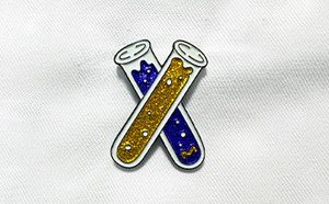 The Pin Hub Pin with two test tubes with blue and yellow glittering liquid inside.