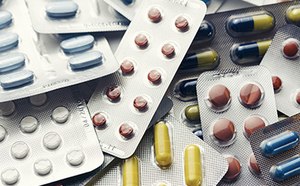 Pharmaceuticals, Illicit Drugs & Alcohol Standards The image displays a collection of various medication pills and capsules, in multiple colors and sizes, packaged in overlapping blister packs.