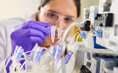 Woman collecting a small volume sample from Mobius Breez bioreactor Woman collecting a small volume sample from Mobius Breez bioreactor
