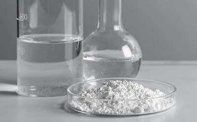 Ultrapure Biochemicals Two beakers with liquid in them and a petri dish with powder in it.