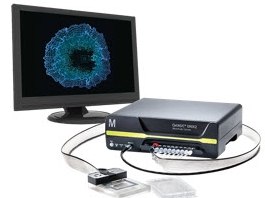 CellASIC® ONIX2 Live Cell Imaging System A computer monitor connected to a black electronic device with multiple ports, showcasing a blue circular pattern on the screen. Two small rectangular objects are placed in front of the device, and two cables connect the monitor to the device.