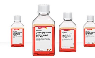 DMEM/F12 Media Four bottles of DMEM F12 Media, containing an orange liquid.