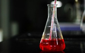 Classical Media and Buffers An Erlenmeyer flask containing red culture media, with a serological pipet drawing up media from the flask