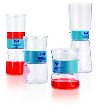 Cell culture media in Stericup® sterile filtration devices A group of six laboratory beakers and flasks, each equipped with blue silicone tops, containing varying levels of red and clear liquids. These containers are arranged in a somewhat staggered composition to display their different shapes and sizes, set against a light background.