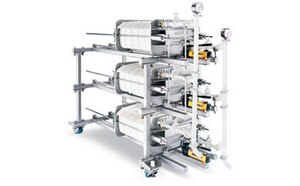 Clarification & Harvest Filtration equipment with multiple cylindrical filters connected by metal piping, set against a white background.