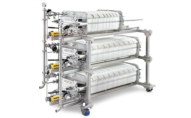 An industrial clarification filter system featuring multiple cylindrical units mounted on a metal frame, complete with gauges and valves, designed for large-scale filtration processes. An industrial clarification filter system featuring multiple cylindrical units mounted on a metal frame, complete with gauges and valves, designed for large-scale filtration processes.