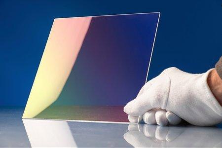 Chalcogenide glass Image of 2-dimensional chalcogenide glass held upright by gloved hand to display the coating.