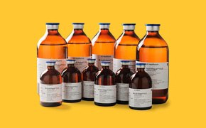 Cell Separation Media A collection of amber glass bottles with white labels, containing cell separation media such as Ficoll-Paque<sup>®</sup> and Percoll<sup>®</sup>, against a yellow background. Several amber glass bottles of varying sizes are arranged in two rows. The bottles have white labels with black text.