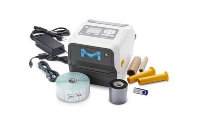 MilliSentials™ Lab Labeling System Portable, compact label printer with a white and grey body featuring a blue “M” logo on the front. Accompanying the printer are various accessories, including a power adapter with cables, three cylindrical objects resembling ink rolls in yellow and black colors, a small blue plastic piece that appears to be part of the printer mechanism, and a roll of labels.