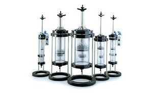 Assorted Vantage<sup>®</sup> Columns A set of five chromatography columns with varying heights, each featuring a clear middle section, black bases and tops, and some with blue valves.