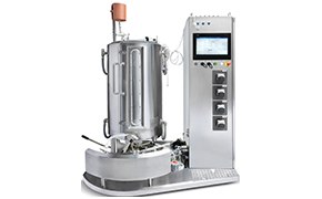 Bioprocessing Systems A machine with a vertical cylindrical chamber and various attached pipes, gauges, and valves, accompanied by an electronic control panel with a screen to the right side.