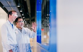 <p>Webinar: A Journey Worth Taking — An Easier Path to Process Change Management</p>
 Two individuals in white lab coats discussing in front of a large screen in a modern lab.