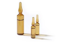 Titripac® packaging for volumetric solutions Two small brown glass vials and one large brown glass vial cast shadows on a white background.
