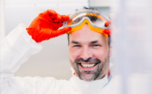 Male Scientist Male scientist with orange safety goggles and red gloves removing his goggles