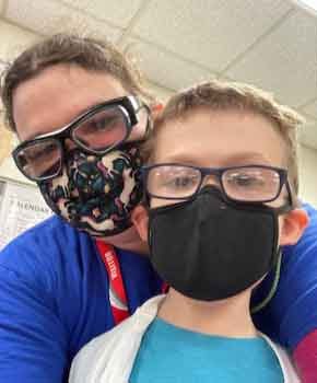 Allison Warn with Son Allison and her son wear safety glasses and masks while taking a selfie.