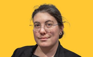 Taylor Szasz-Green Taylor Szasz-Green headshot with a vibrant yellow background