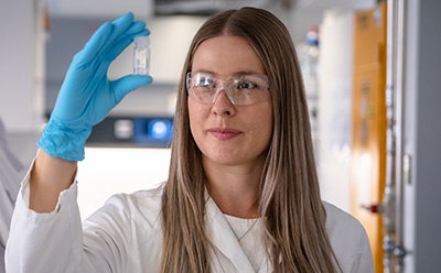 Lab worker holding glass vial Lab worker holding glass vial