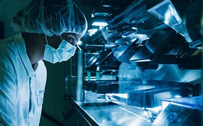 A masked scientist performing quality control A masked scientist performing quality control
