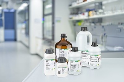 A variety of laboratory Emsure solvent bottles, labeled with product information, placed on a white counter in a modern laboratory setting. The bottles vary in size and shape, with both amber and white bottles visible, representing different chemical solvents typically used in analytical and research labs. The background features lab equipment and shelves A variety of laboratory Emsure solvent bottles, labeled with product information, placed on a white counter in a modern laboratory setting. The bottles vary in size and shape, with both amber and white bottles visible, representing different chemical solvents typically used in analytical and research labs. The background features lab equipment and shelves