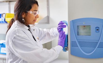 Scientist at the -80C freezer Female scientist closing the -80C freezer door.